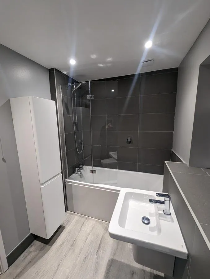 Bathroom with a tall white cabinet, bath and basin